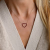 Woman wearing a Rosecliff Heart Necklace featuring twenty faceted round cut garnets prong set in 14k yellow Gold