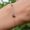 Woman wearing a Grand & Classic bracelet featuring one 6 mm and four 4 mm briolette Rubies bezel set in 14k yellow gold