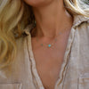 Woman wearing a Grand & Classic necklace featuring one 6 mm Turquoise & four 4 mm Nantucket Blue Topaz bezel set in 14k gold