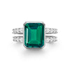 Warren ring in 14k white gold with accent diamonds featuring one 10 x 8 mm emerald cut bezel set emerald - front view