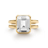 Warren ring in 14k yellow gold featuring one 10 x 8 mm emerald cut bezel set white topaz - front view