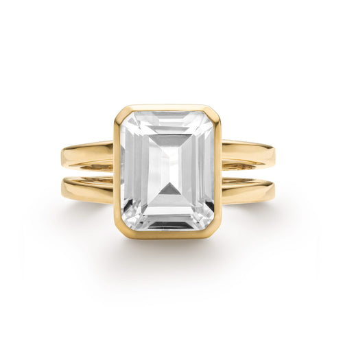 Warren ring in 14k yellow gold featuring one 10 x 8 mm emerald cut bezel set white topaz - front view