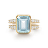 Warren ring in 14k yellow gold with accent diamonds featuring one 10 x 8 mm emerald cut Nantucket blue topaz - front view