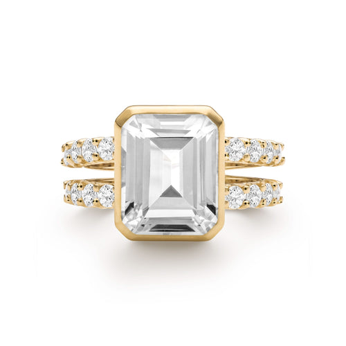 Warren ring in 14k gold with accent diamonds featuring one 10 x 8 mm emerald cut bezel set white topaz - front view