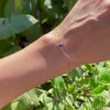 Woman wearing a Grand 1.17 mm cable chain bracelet in 14k yellow gold featuring one 6 mm briolette cut bezel set amethyst
