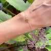 Woman wearing a Grand 1.17 mm cable chain bracelet in 14k yellow gold featuring one 6 mm briolette cut bezel set citrine