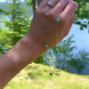 Hand holding a Bayberry Grand & Classic 14k gold necklace featuring alternating 4 mm & 6 mm Nantucket blue topaz & turquoises