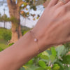 Woman with a Grand & Classic bracelet featuring one 6 mm Pink Opal and four 4 mm Pink Tourmalines bezel set in 14k gold