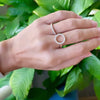 Hand with two rings including a Rosecliff open circle ring featuring sixteen 2 mm diamonds prong set in 14k yellow gold
