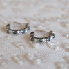 A pair of Rosecliff huggie earrings in 14k gold each featuring nine alternating 2 mm round cut alexandrites and diamonds