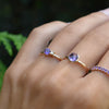 Woman wearing three rings including a Greenwich ring featuring one 4 mm amethyst and one 2.1 mm diamond prong set in 14k gold