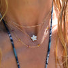 Woman wearing layered necklaces including a Sunset necklace featuring Pink Tourmalines and Citrines bezel set in 14k gold