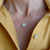 Woman wearing two 14k yellow gold necklaces including a Greenwich necklace featuring five 4 mm opals and one 2.1 mm diamond