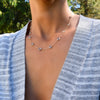 Woman wearing a Grand 14k gold 1.17 mm cable chain necklace featuring ten 6 mm briolette cut bezel set gemstones