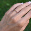 Hand wearing a Rosecliff stackable ring featuring eleven alternating 2mm citrines and diamonds prong set in 14k yellow gold
