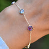Woman's hand with a Grand 1.17 mm cable chain bracelet in 14k gold featuring four 6 mm briolette cut bezel set gemstones