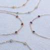 Multiple Bayberry 1.17 mm cable chain birthstone bracelets each featuring three 4 mm gemstones bezel set in 14k gold