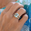 Woman's hand wearing a Warren ring in 14k gold with accent diamonds featuring one 10 x 8 mm emerald cut Nantucket white topaz