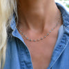 Woman with a Newport necklace featuring 4 mm briolette cut Nantucket blue topaz bezel set in 14k yellow gold