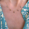 Woman wearing a Providence 5 Alexandrite drop necklace with petite baguette cut stones set in 14k yellow gold