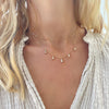 Woman wearing a Providence 5 White Topaz drop necklace with petite baguette cut stones set in 14k yellow gold