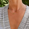 Woman wearing a Grand 14k gold 1.17 mm cable chain necklace featuring three 6 mm briolette cut bezel set gemstones