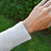 Woman wearing a 14k gold Adelaide paperclip chain pavé bracelet featuring gemstone-encrusted links