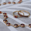 Assorted jewelry including a Rosecliff stackable ring featuring eleven 2 mm faceted round cut garnets prong set in 14k gold