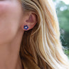 Woman wearing a 14k yellow gold Greenwich 5 Birthstone earring featuring five 4 mm sapphires and one 2.1 mm diamond