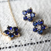 Pair of Greenwich earrings and a necklace in 14k yellow gold featuring 4 mm faceted round cut sapphires and 2.1 mm diamonds