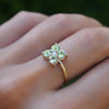 Woman with a Greenwich ring featuring four 4 mm faceted round cut peridots and one 2.1 mm diamond prong set in 14k gold