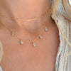Woman wearing a Providence 5 Aquamarine drop necklace with petite baguette cut stones set in 14k yellow gold