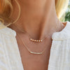 Woman wearing two Rosecliff bar necklaces including one with 11 alternating 2 mm citrines and diamonds prong set in 14k gold