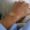 Woman wearing multiple bracelets including a 14k gold Adelaide mini bracelet featuring 5.2 x 2 mm paperclip chain links