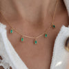 Woman wearing a Providence 5 Emerald drop necklace with petite baguette cut stones set in 14k yellow gold