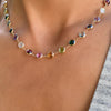 Woman wearing a Newport Grand 14k yellow gold necklace featuring 6 mm rainbow hued briolette cut bezel set gemstones