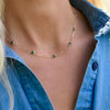 Woman wearing a Bayberry 11 Birthstone necklace featuring 4 mm briolette emeralds bezel set in 14k yellow gold