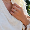 Woman wearing three Rosecliff stackable rings in 14k yellow gold featuring 2mm faceted round cut prong set gemstones