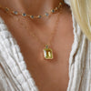 Woman with an Adelaide paper clip chain with a Warren emerald cut bezel set lemon verbena quartz pendant in 14k gold
