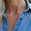 Woman wearing a Newport necklace featuring 4 mm briolette cut white topaz bezel set in 14k yellow gold