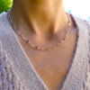 Woman with a Pink Awareness Newport necklace featuring alternating 4 mm pink tourmalines & moonstones bezel set in 14k gold