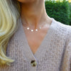 Woman wearing a Pink Awareness Love necklace featuring four 4 mm Pink Tourmalines and four 1/4” flat engraved letter discs