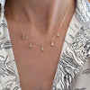 Woman wearing a Providence 5 White Topaz drop necklace with petite baguette cut stones set in 14k yellow gold