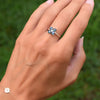 Woman wearing a Greenwich ring featuring four 4 mm faceted round alexandrites and one 2.1 mm diamond prong set in 14k gold