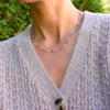 Woman wearing a Pink Awareness Newport necklace featuring alternating 4 mm pink tourmalines & moonstones set in 14k gold