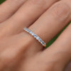 Hand wearing a Rosecliff stackable ring featuring eleven 2 mm faceted round cut aquamarines prong set in 14k yellow gold