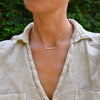 Woman wearing a Rosecliff bar necklace with eleven alternating 2 mm faceted round cut gemstones prong set in solid 14k gold