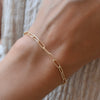 Woman wearing a 14k gold Adelaide bracelet featuring 8.4 x 3 mm paperclip chain links and a lobster claw clasp