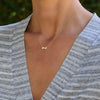 Woman wearing a Greenwich cable chain necklace featuring two 4 mm white topaz and one 2.1 mm diamond bezel set in 14k gold