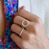 Woman wearing two rings including a Rosecliff open circle ring featuring sixteen 2 mm diamonds prong set in 14k gold